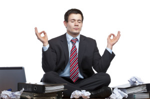 Business man meditating to reduce stress and IBS.