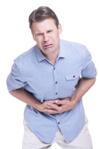 A Man holds his stomach in extreme pain.