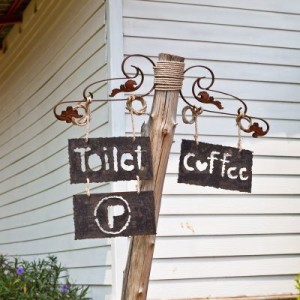 Sign pointing to coffee and the toilet.