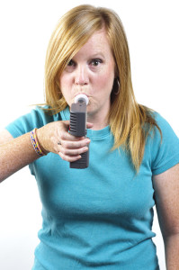 Woman blowing into a hydrogen breath test machine.